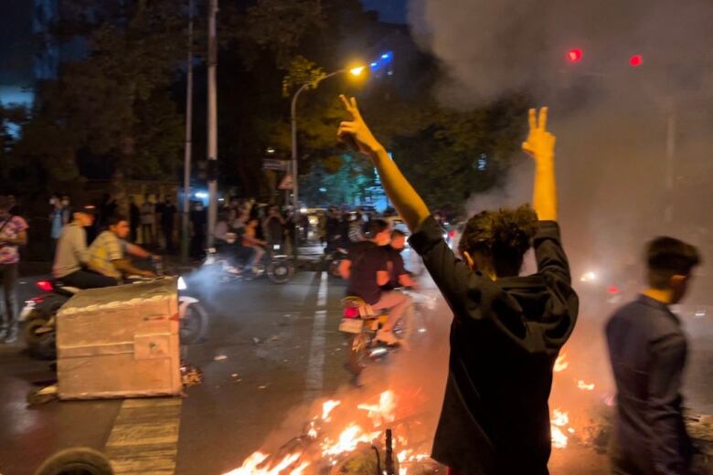 Picture obtained by AFP outside Iran shows shows a demonstrator raising his arms and makes the victory sign during a protest for Mahsa Amini, a woman who died after being arrested by the Islamic republic's 