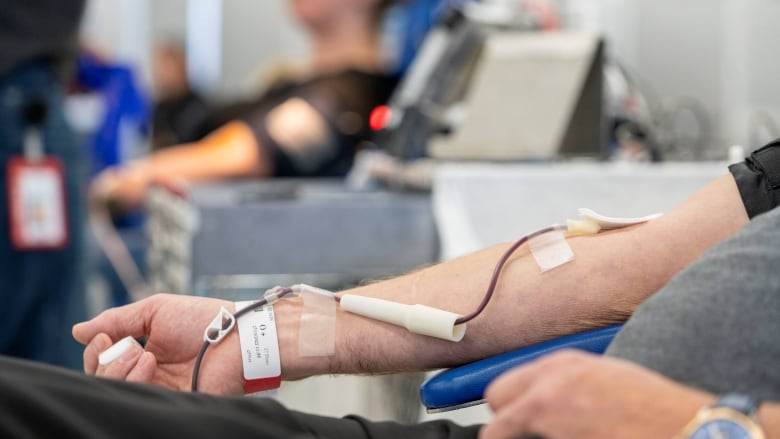 a man's arm is hooked up to a blood bag.