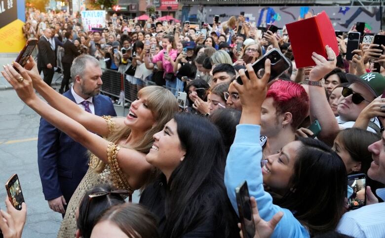 Singer Taylor Swift poses for a selfie with fans as she arrives to speak at the Toronto International Film Festival (TIFF) in Toronto, Ontario, Canada September 9, 2022. REUTERS/Mark Blinch