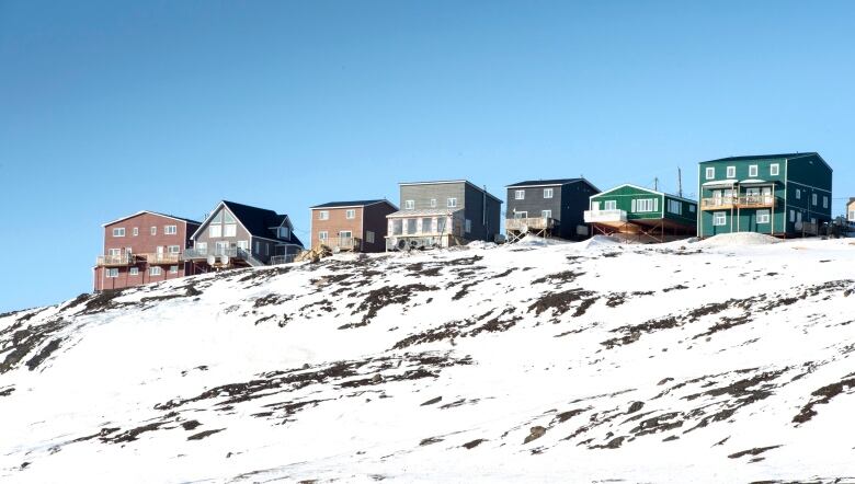 A row of houses overlook a hill in Iqaluit.