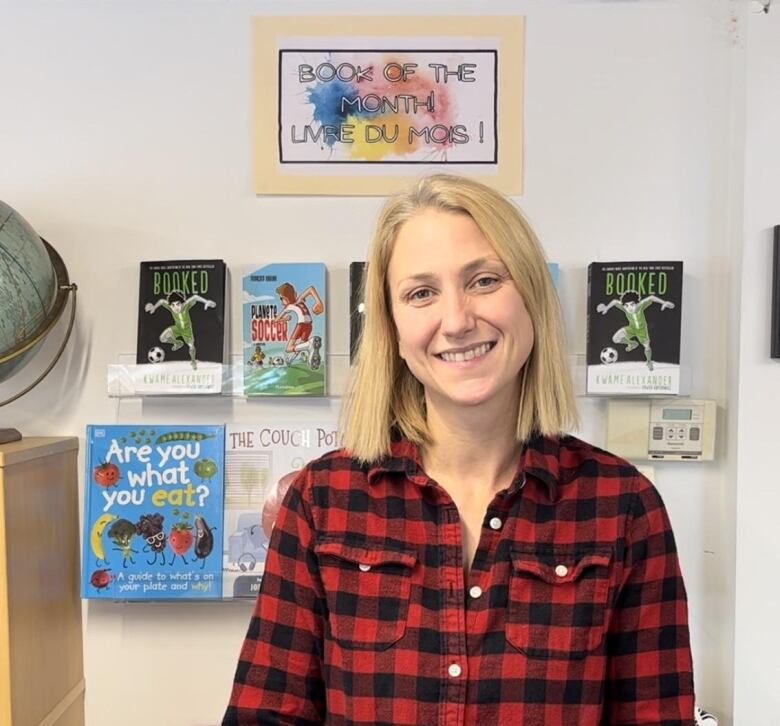 A woman stands in front of children's books.