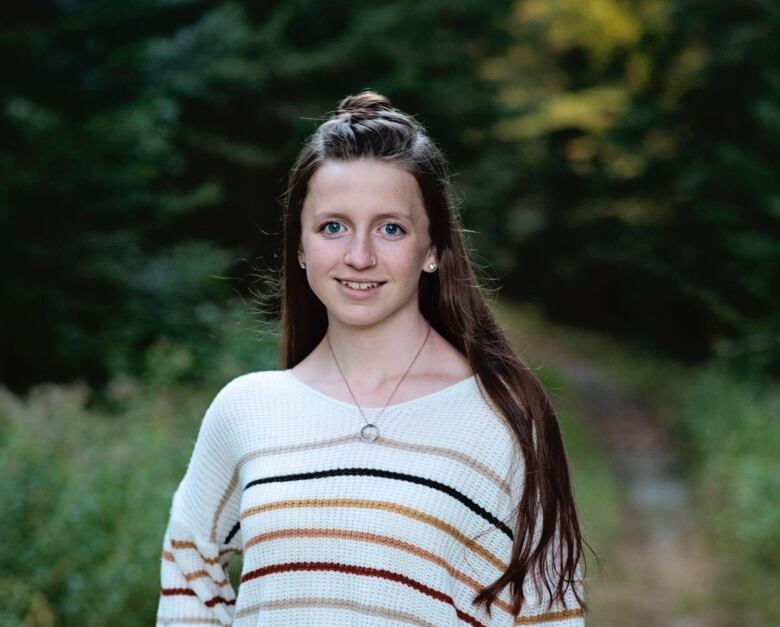 A teenage girl smiles for the camera.