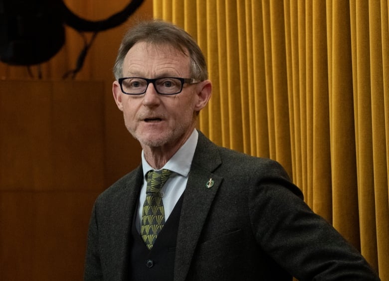 Man in glasses and a tie looking at the camera