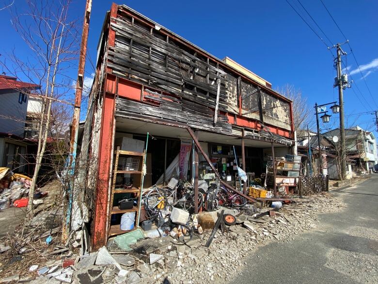 An abandoned shed filled with clutter.