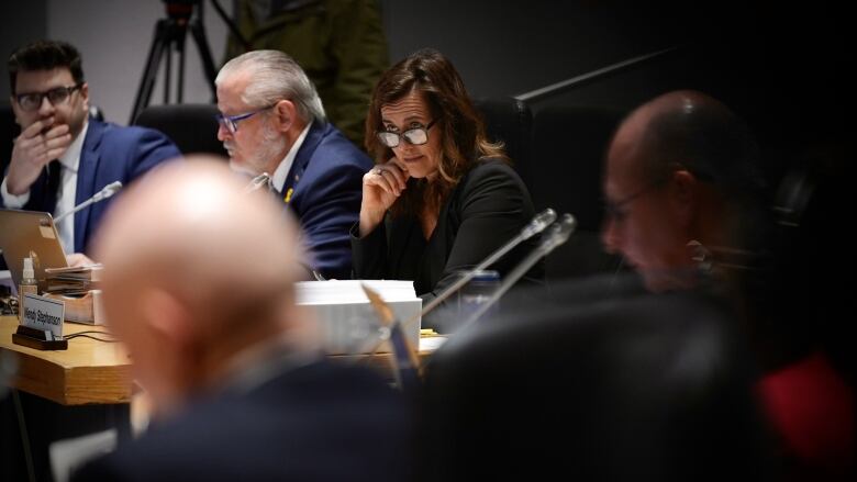 A woman looks over her glasses at a meeting