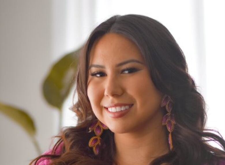 A woman in bright clothing smiles at the camera