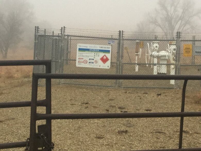 a view of a metal fence in front of a field. 