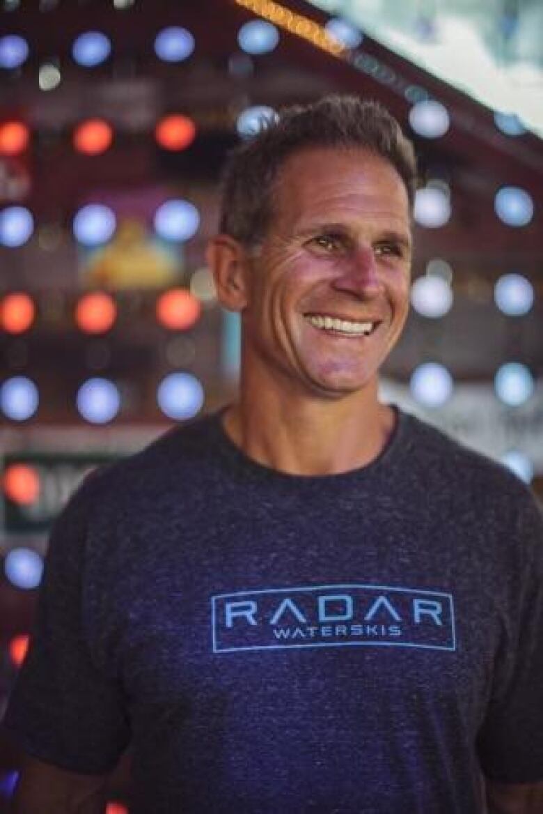 Stopnicki's coach, Matt Rini, wearing a RADAR Waterskis tee shirt and smiling.