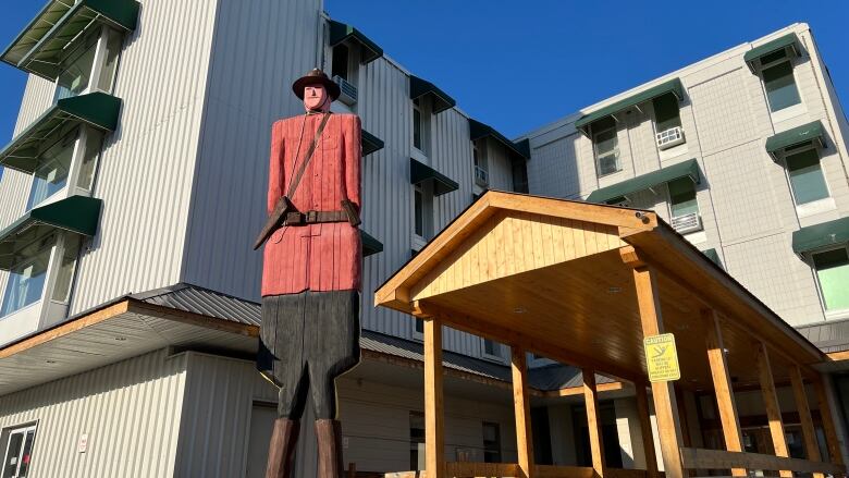 A 30 ft wooden statue that looks like a Canadian mountie.