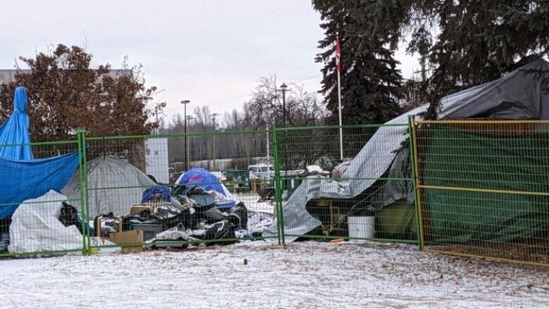 tents behind a fence with snow on the ground