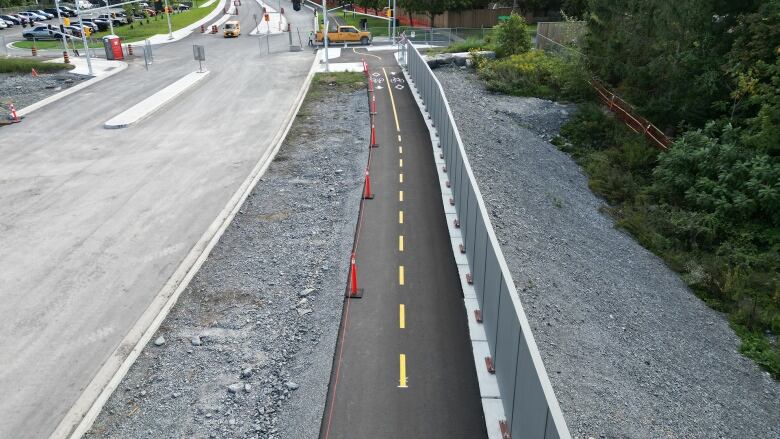 Two bike lanes are shown running along the side of a bridge that's under contruction.