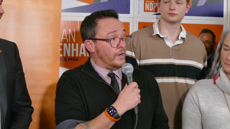 A man speaks into a microphone.