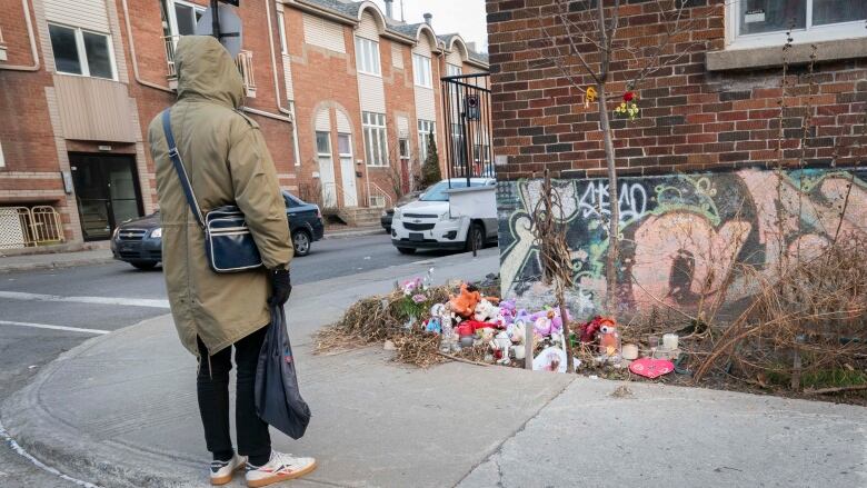 A person stands in front of a memorial