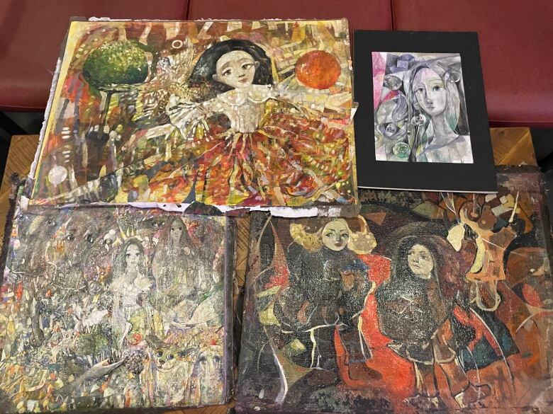 Close up of several paintings by Gledova with lots of colours and faces.