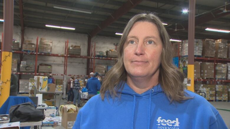 A woman is seen in a warehouse wearing a blue 