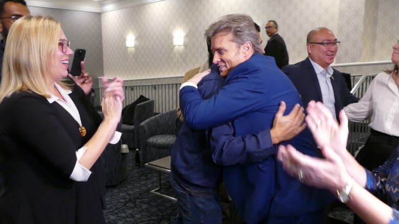 Kevin Klein, centre, hugs PC cabinet minister after winning the Kirkfield Park byelection.