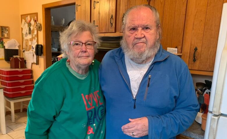 A couple stands in their kitchen 