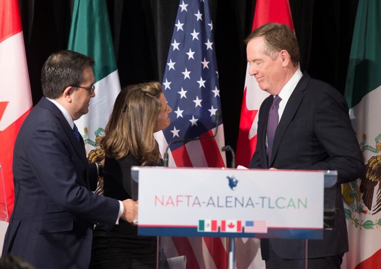 A woman and two men shake hands during trade talks between Canada, the United States and Mexico in 2018. 