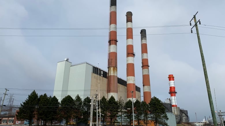 Four red and white smokestacks stand against the sky.