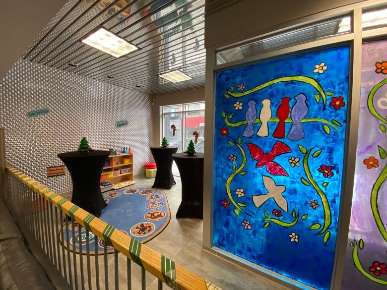 The lobby of a community centre with bright artwork depicting birds.