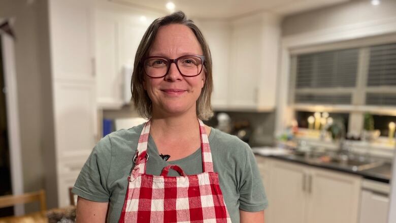 A woman standing in her kitchen