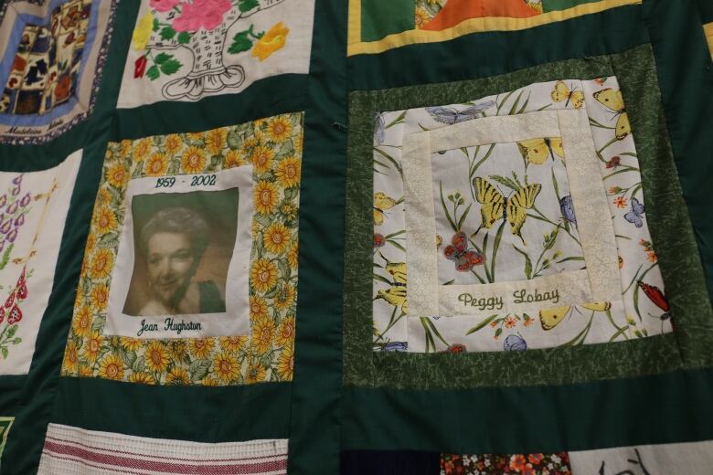 A green quilt includes squares that honour individual members of the club. Jean Hughston and Peggy Lobay's squares are pictured.