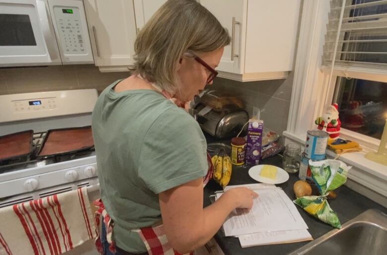 A woman looks at a cook book 