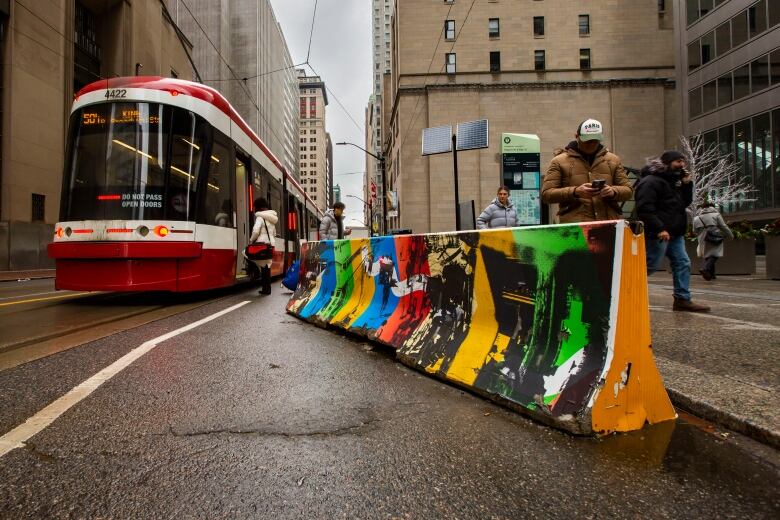 People boarding and exiting a streetcar on King Street.