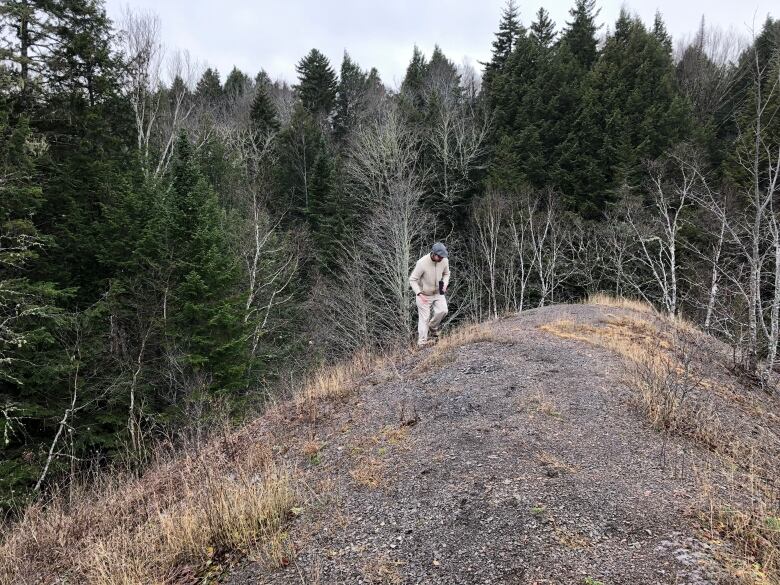 James Upham climbs tailings pile in Albert Mines