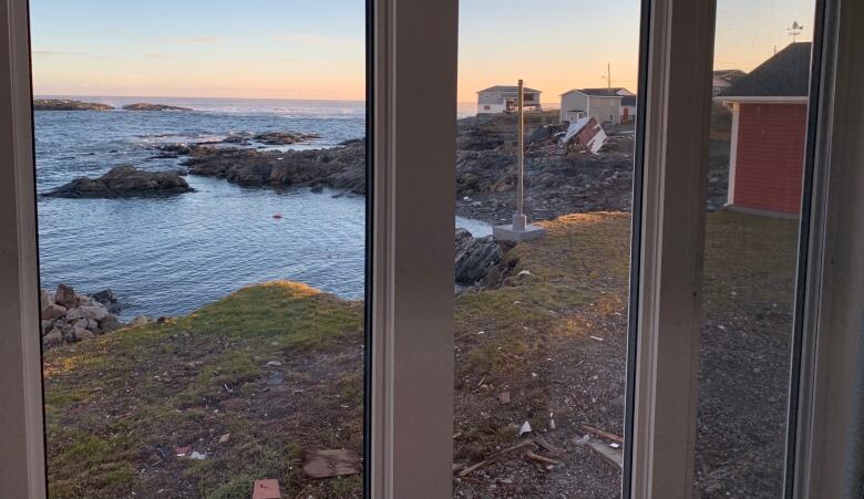 A view of the sunsetting on the ocean from Scott Strickland's dining room. A damaged home can be seen on the right. 