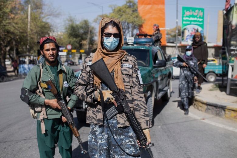 Taliban fighters stand guard during a women's protest in Kabul, Afghanistan on Thursday, Oct. 21, 2021.