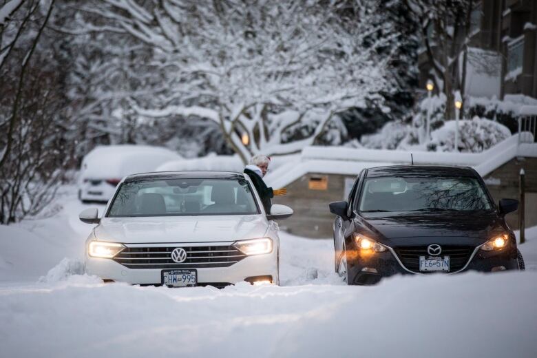 Two cars are pictured stuck in the snow.