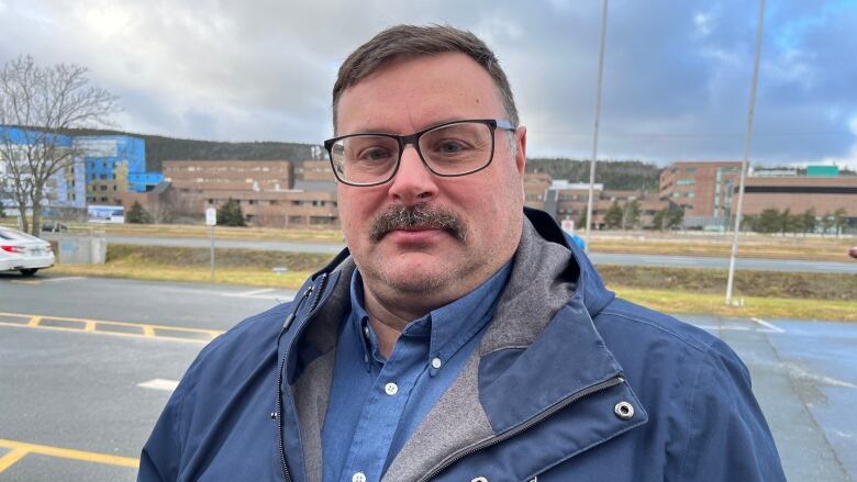 A man wearing a blue jacket stands in the CBC parking lot in St. John's.