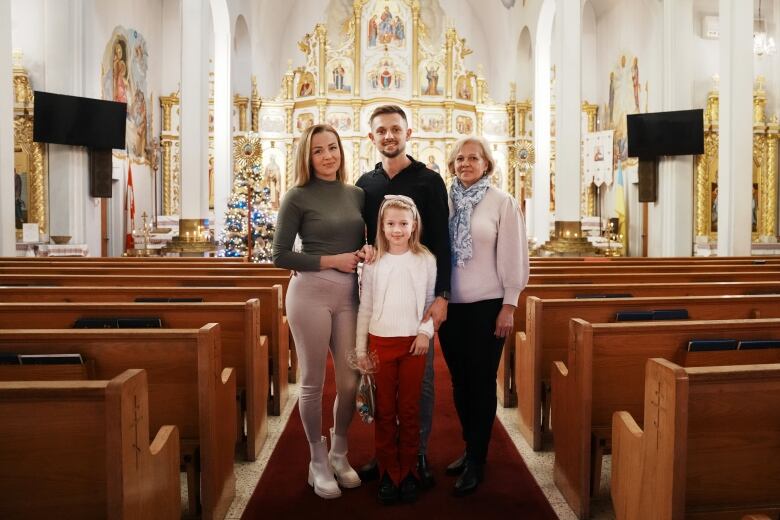 Vitali Hrechka poses for a photo with his wife Evelina, daughter Emiliia, and mother Hanna, after the St. Nicholas Day celebration at St. Demetrius Ukrainian Orthodox Church in Toronto on Sunday, Dec. 18, 2022.