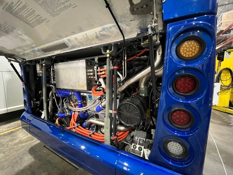 A panel on a bus sits open to reveal a hydrogen fuel cell.