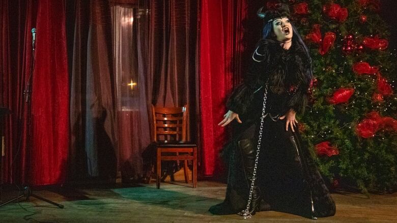 A drag performer dances on stage dressed as Krampus.