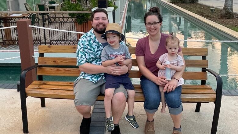 A man and woman sit with their kids.