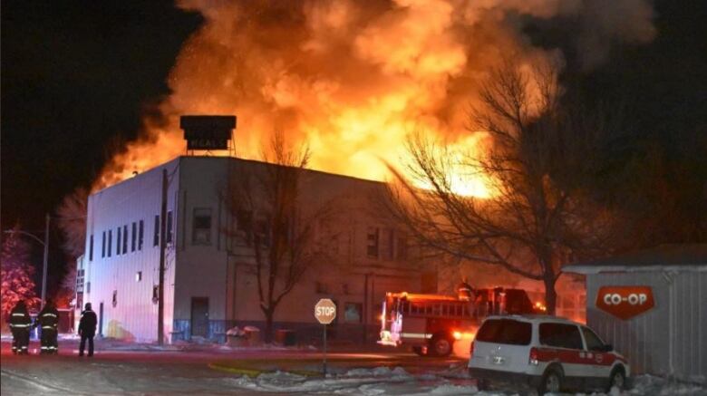 Flames pour out the top of a building.