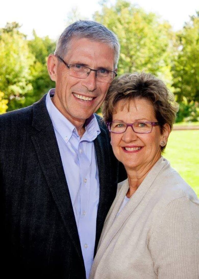 A man and woman smile at the camera