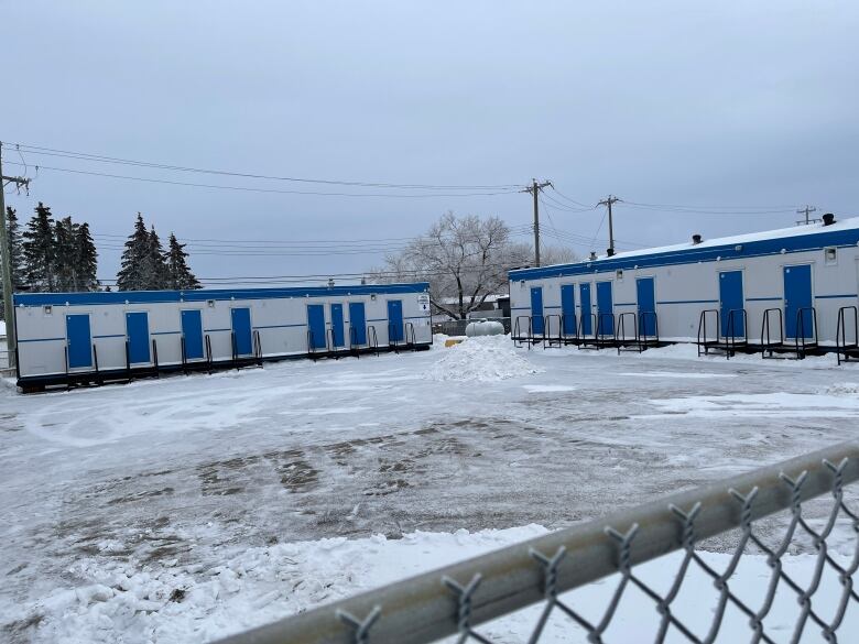 Two rows of trailers sit on a lot known as the Drayton Valley Shelter Pods. Individual rooms are used as overnight shelter for residents.