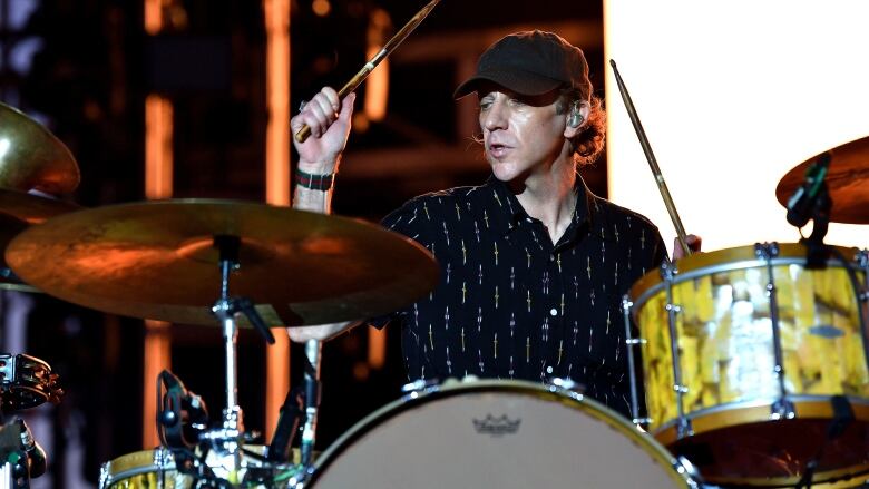 A man plays on a drum kit.