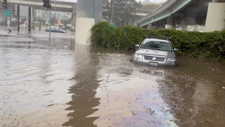 Cars are seen partially submerged on a flooded road.