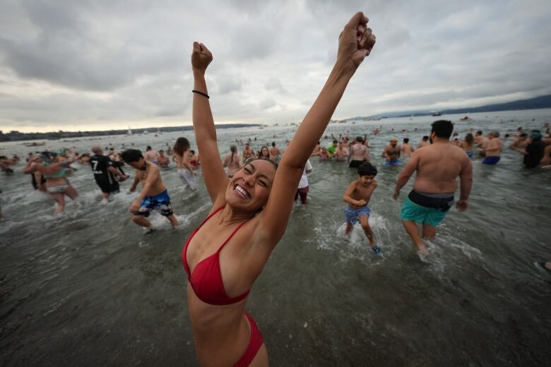 A woman reacts as she runs out of the water after plunging into Vancouver's English Bay during the Polar Bear Swim on New Year's Day.