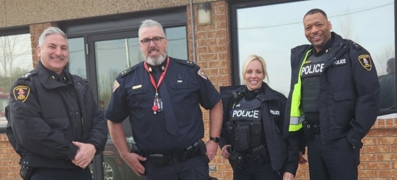 Four police officers standing outside a police station