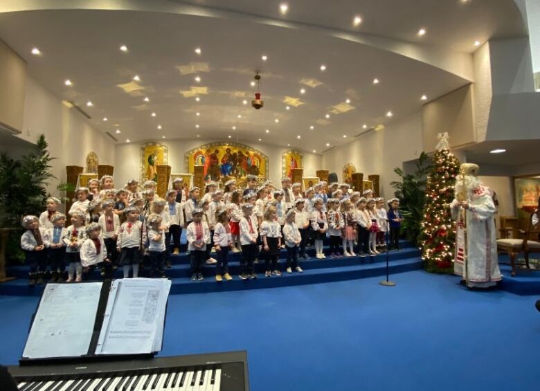 Junior and senior kindergarten students can be pictured decked in Christmas-themed gear at a church.