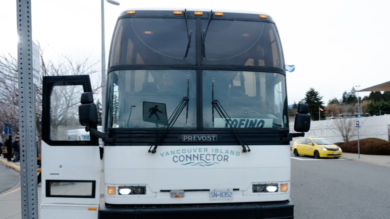 A Vancouver Island Connector coach bus is pictured with a Tofino sign sitting in the front window. 