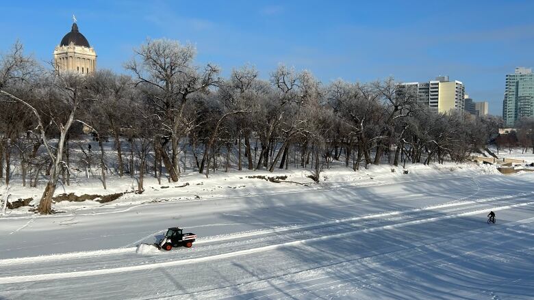 Looking down at the snow-covered Assiniboine River from a bridge.