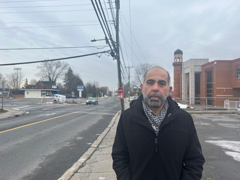 A man in front of a mosque.