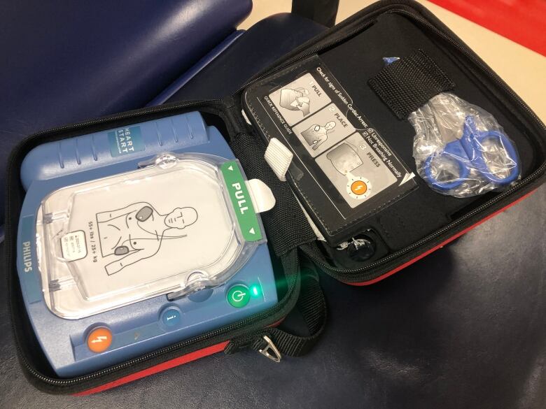 A defibrillator typically mounted near University of Winnipeg sports courts is shown opened up on a bench.