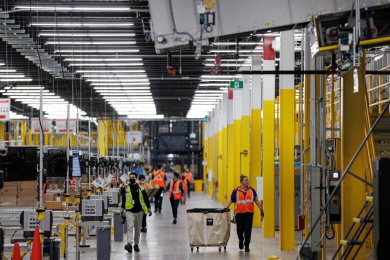 A bustling warehouse with workers walking around.